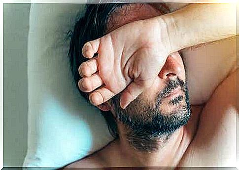 A man wakes up with his hand in front of his face