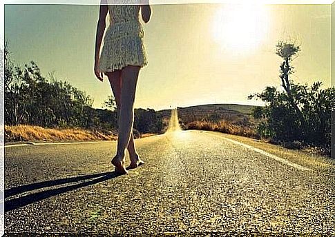 Girl walking barefoot on a road