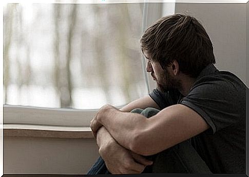 Man in emotional distress looks out the window