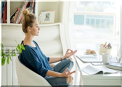 Woman meditating behind her desk