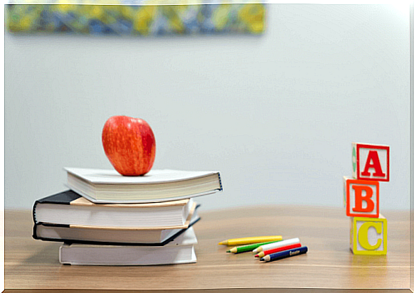 Stack of books with an apple on them, to make learning more fun for children with learning disabilities