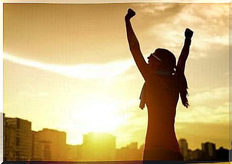 A woman raises her arms in joy