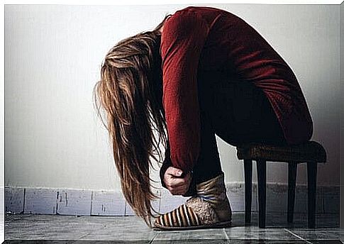 Girl sitting bent over on chair