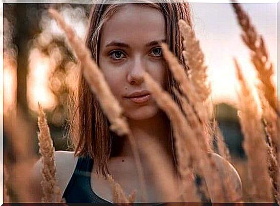 Girl standing in a wheat field and one of those brave people who always have a smile on their face