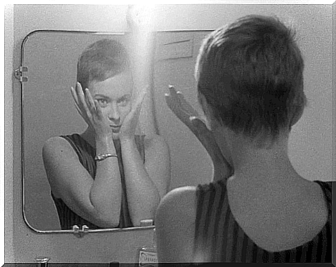 Girl playing peekaboo with herself in the mirror